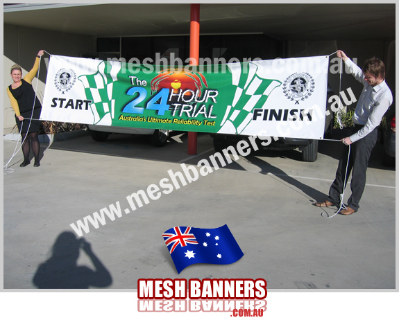 People holding 24 Hour Start Finish Race Banner Sign