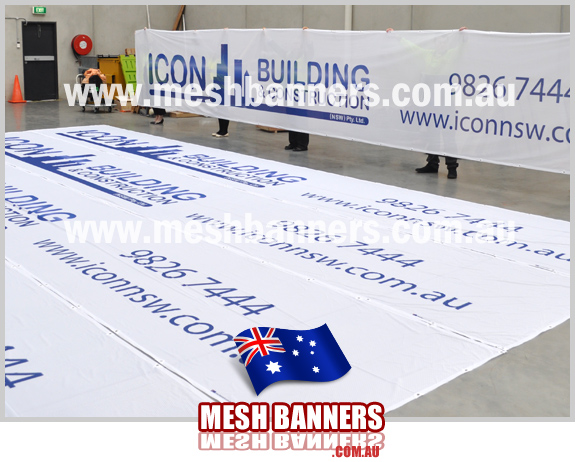 Icon People holding up 10 metre construction mesh section of banner = 50m