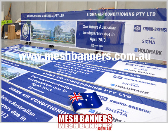 People behind the mesh banner sign
