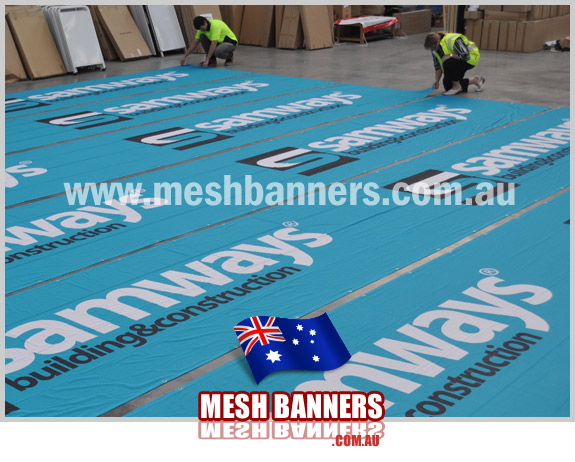 Workers making the temp fence banner signs